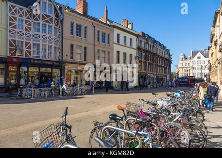 Oxford, Inghilterra - 8 Aprile 2017 - le biciclette parcheggiate e persone appendere fuori negozi intorno a una strada di Oxford University, Inghilterra in una bella giornata di primavera di AP Foto Stock