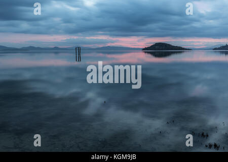 Perfetta e simmetrica riflessioni su un lago al tramonto, con caldi e toni morbidi Foto Stock