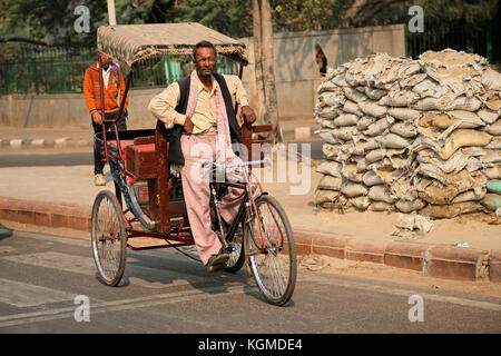 Delhi, India - 20 novembre 2015: Uomo indiano seduto su un risciò in bicicletta in attesa che le persone trasportino Foto Stock