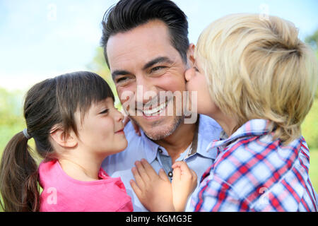 Ritratto di bambini che dà un bacio al loro papà Foto Stock