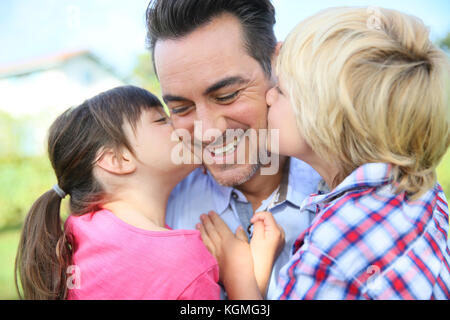 Ritratto di bambini che dà un bacio al loro papà Foto Stock