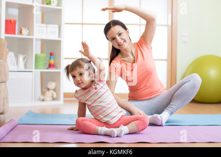 Attiva la madre e il bambino figlia sono impegnati nel fitness, yoga e fitness in casa Foto Stock