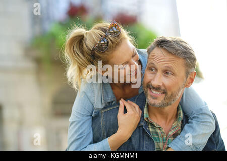 L uomo dando piggyback ride per donna Foto Stock