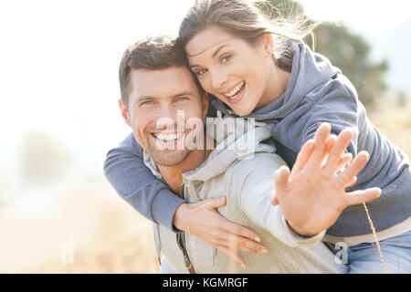 L uomo dando piggyback ride per ragazza in campagna Foto Stock