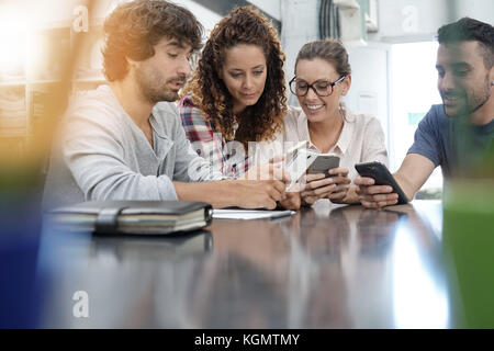 Un gruppo di giovani a giocare con gli smartphone Foto Stock