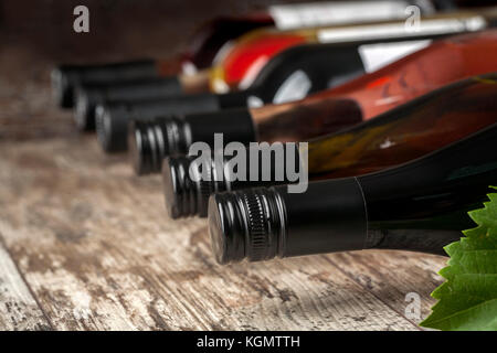 Le bottiglie di vino impilati su un tavolo di legno shot con limitata profondità di campo Foto Stock