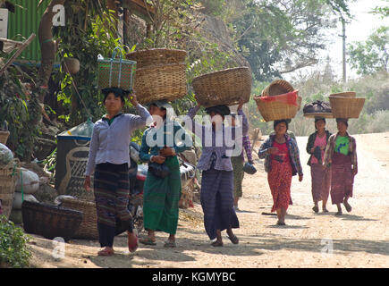 Donne cestini di bilanciamento delle merci sul loro capo a Bagan Myanmar Foto Stock