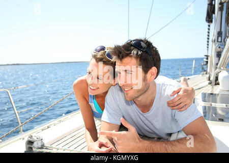 Giovane rilassante sul ponte di barche a vela Foto Stock