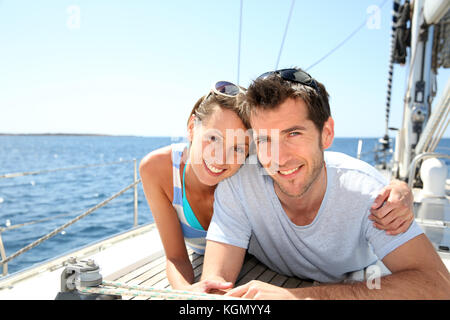 Giovane rilassante sul ponte di barche a vela Foto Stock