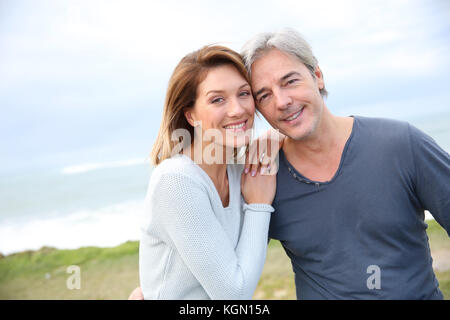 Allegro di mezza età matura sulla fascia costiera sull'oceano Foto Stock