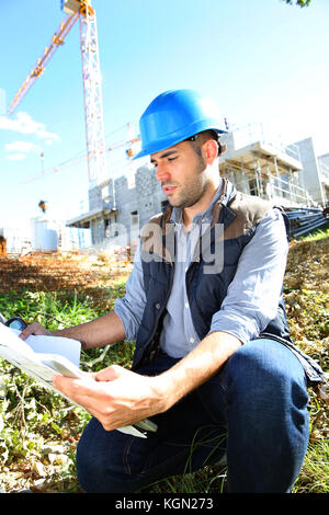 Costruzione manager utilizzando un walkie-talkie sul sito Foto Stock