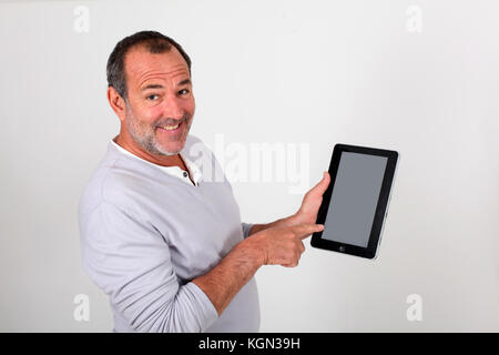 Senior uomo puntando alla pagina web sulla tavoletta elettronica Foto Stock