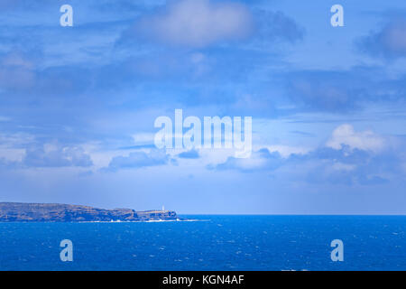 Faro permanente sulla rupe robusto Edge che si affacciano sull'oceano blu in australia Foto Stock