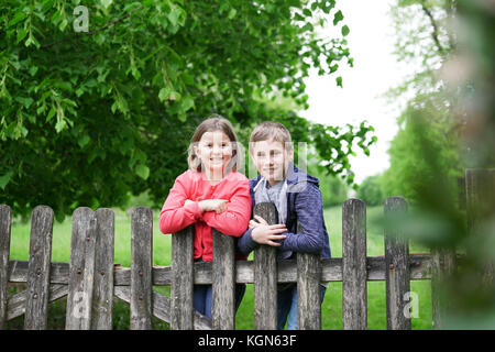 Ritratto di arrampicata per bambini sulla recinzione in campagna Foto Stock