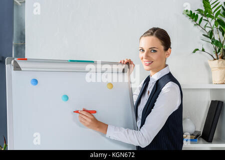 Imprenditrice iscritto su whiteboard Foto Stock