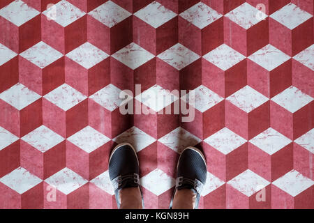 Selfie di piedi con scarpe sneaker sul modello di arte pavimento in piastrelle di colore rosso e bianco cubo 3d Foto Stock