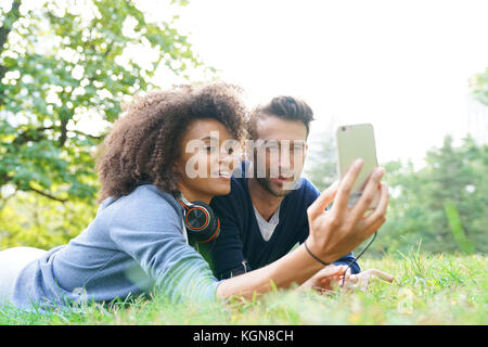 Mixed-corso giovane che stabilisce nel parco centrale di erba Foto Stock