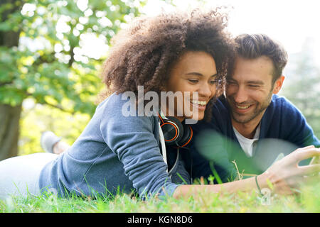 Mixed-corso giovane che stabilisce nel parco centrale di erba Foto Stock