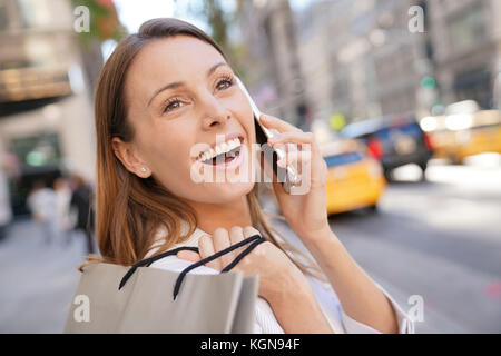 Allegro shopping Ragazza di Manhattan e parlando al telefono Foto Stock