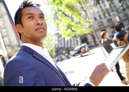 Imprenditore a Manhattan con tavoletta digitale Foto Stock