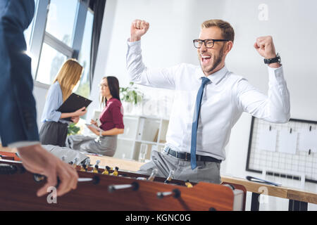 Imprenditori a giocare il calcio balilla Foto Stock