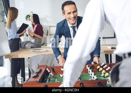 Imprenditori a giocare il calcio balilla Foto Stock