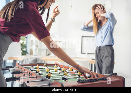 Imprenditrici la riproduzione di un tavolo da calcio balilla Foto Stock