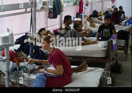 Malumghat, Bangladesh. 9 Nov 2017. Heidi Reimer, un'infermiera di Spokane, WA, controlla un giovane rifugiato Rohingya nell'unità di cura Rohingya del Memorial Christian Hospital di Malumghat, Bangladesh. L'unità sta operando a capacità di trattamento dei rifugiati Rohingya in arrivo che soffrono di un'ampia gamma di lesioni da ferite da sparo, ossa rotte da cadute traumatiche in fuga e altri disturbi aquistati durante il loro volo da Myanmar. Credit: Chuck Bigger/Alamy Live News Foto Stock