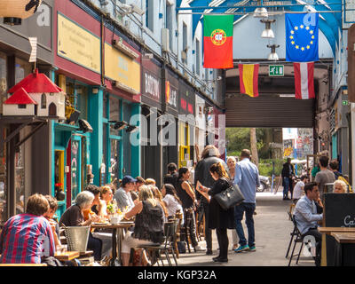 La gente mangia nei ristoranti del villaggio di Brixton in Brixton- una delle parti più vibranti e multiculturali Londra Foto Stock