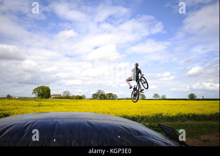 Mountain bike a chicksands, bedfordshire. piloti salta fuori da un grande togliere la rampa verso un enorme airbag. cercando & perfezionando nuovi trucchi. Foto Stock