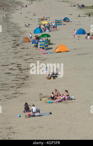 Ripresa a tutto campo dei vacanzieri su una spiaggia della Cornovaglia su un soleggiato a ferragosto. Foto Stock