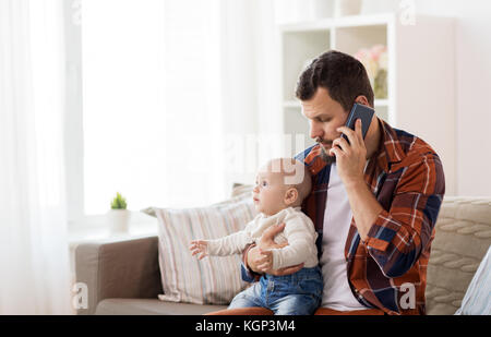 Padre con il bambino chiamando sullo smartphone a casa Foto Stock