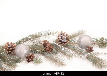 Decorazione di natale con le sfere di argento e ghirlande, rami di abete e coni Foto Stock