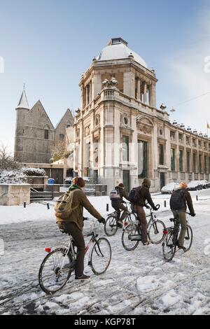 I bambini a scuola in bicicletta in inverno attraverso le strade di Gand, Belgio Foto Stock