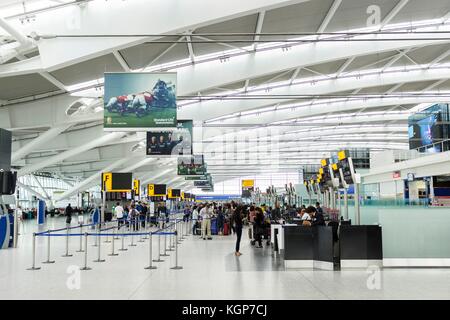 I passeggeri devono fare la fila per il check-in nella sala partenze del Terminal 5, Aeroporto di Heathrow Foto Stock
