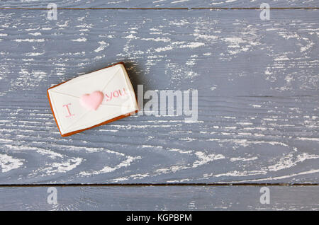 Rosa e Bianco cookie romantica su un grigio Sfondo di legno con spazio di copia Foto Stock