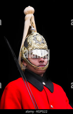 Uno dei Queen's montato vita delle guardie con la spada in servizio al di fuori dell'Horse Guards edificio su Whitehall, Londra, Inghilterra. Foto Stock