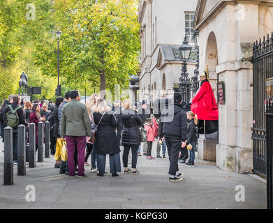 Turisti e sightweers coda per posare con una sentinella montato della regina della vita delle guardie al di fuori dell'Horse Guards building a Whitehall a Londra, Inghilterra Foto Stock