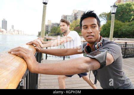 Asian guy stirando dopo esercizio Foto Stock