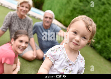 Ritratto di carino 2-year-old girl, famiglia in background Foto Stock