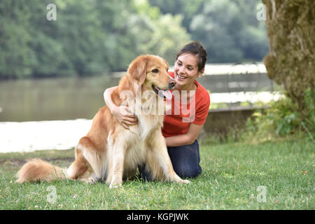 Donna rilassante con il cane al parco Foto Stock