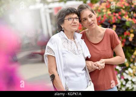 Home caregiver aiutando donna disabile a piedi con stampella Foto Stock