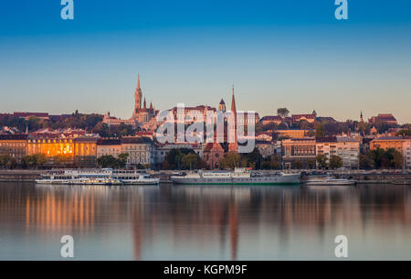 Budapest, Ungheria - Vista Alba del lato Buda di Budapest con il Castello di Buda, la chiesa di San Mattia e il Bastione dei pescatori con vecchie navi sulla Rive Foto Stock