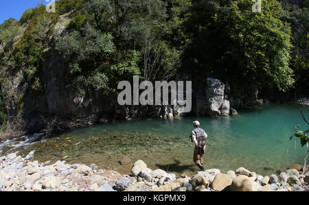 Pescatore a mosca la pesca nel fiume di montagna Foto Stock