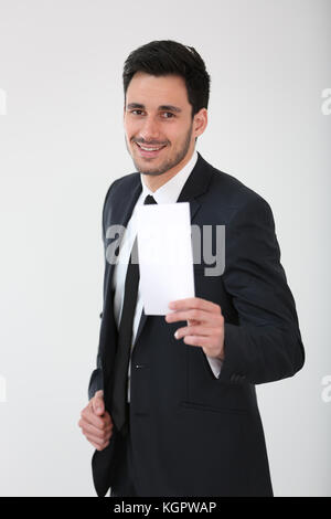 Imprenditore sorridente holding blank flyer Foto Stock