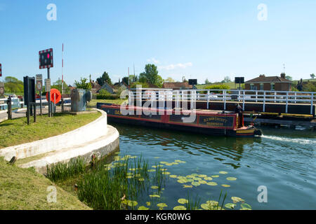 Un colorato narrowboat passa attraverso il ponte girevole a Purton su Gloucester & Nitidezza Canal at Purton in estate il sole, Gloucestershire, Regno Unito Foto Stock