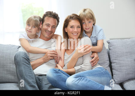 La famiglia felice rilassante sul lettino a casa Foto Stock