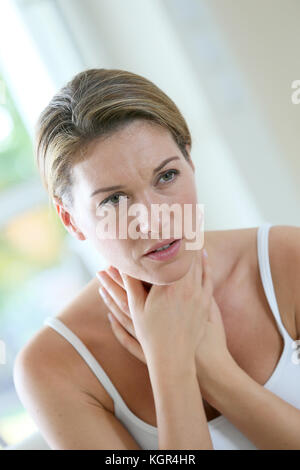 Donna di mezza età avente un freddo e la tosse Foto Stock