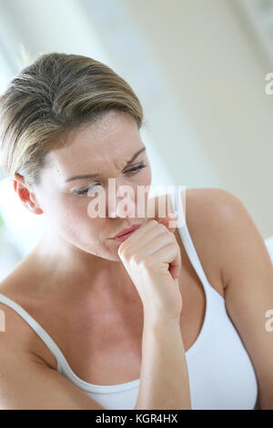 Donna di mezza età avente un freddo e la tosse Foto Stock