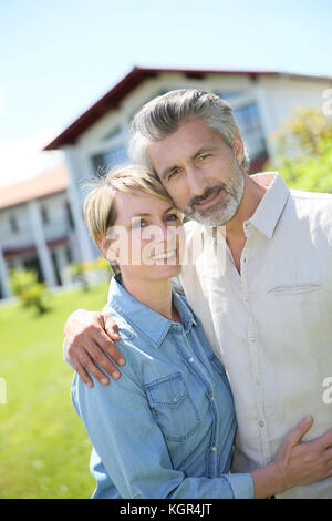 Matura in piedi nella parte anteriore della nuova casa di proprietà Foto Stock